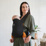 Maman de profil avec son joli porte-bébé physio en coton et lin bio Rookie Premium Noir