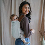 Bébé dans son porte-bébé rookie revolution beige portage dorsal