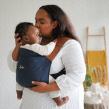 Maman portant bébé dans son porte-bébé physiologique en mode ventral Rookie Revolution - Bleu Marine/Marron