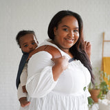 Maman de profil avec son joli porte-bébé physio en coton et lin bio Rookie Revolution - Bleu Marine/Marron