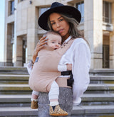 Maman en extérieur avec son joli porte-bébé physio en coton et lin bio Rookie Premium Latte